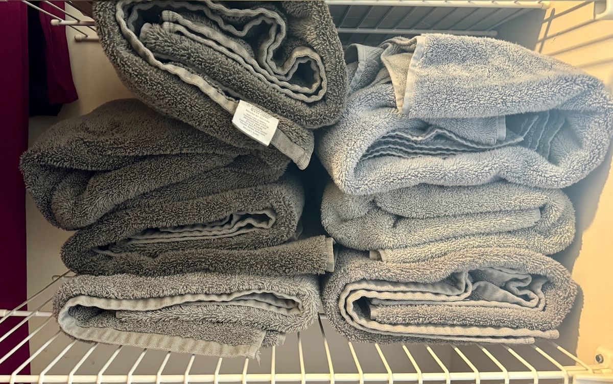 Seven towels on a closet shelf